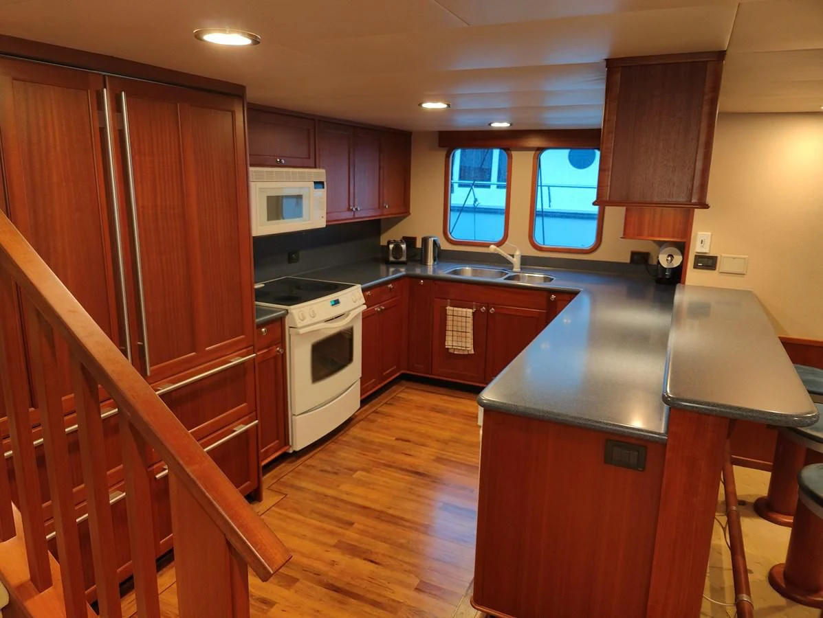 a kitchen with wooden cabinets aboard SPELLBOUND Yacht for Sale