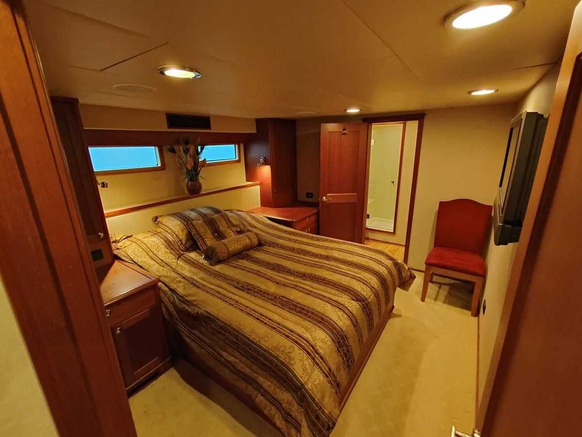 a hotel room with a bed and a chair aboard SPELLBOUND Yacht for Sale