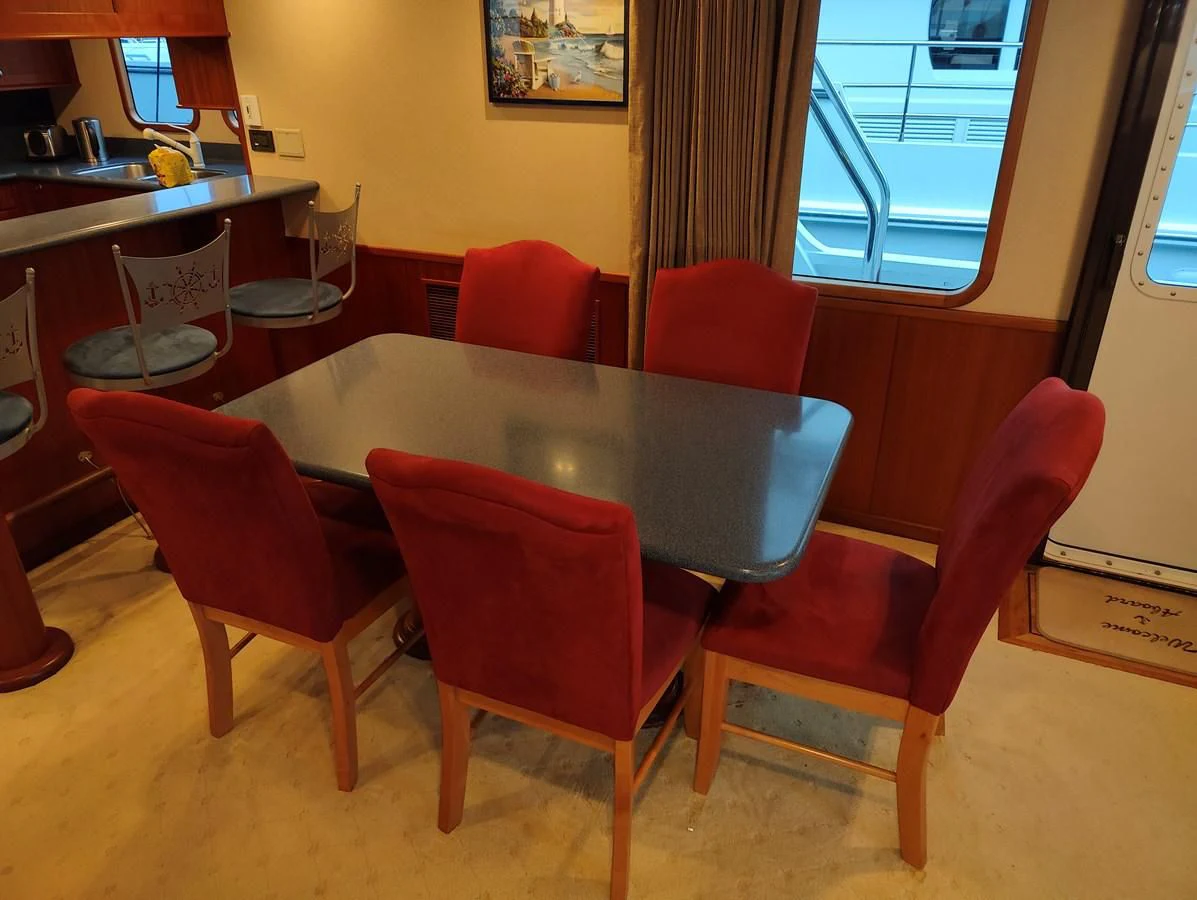 a table with red chairs aboard SPELLBOUND Yacht for Sale