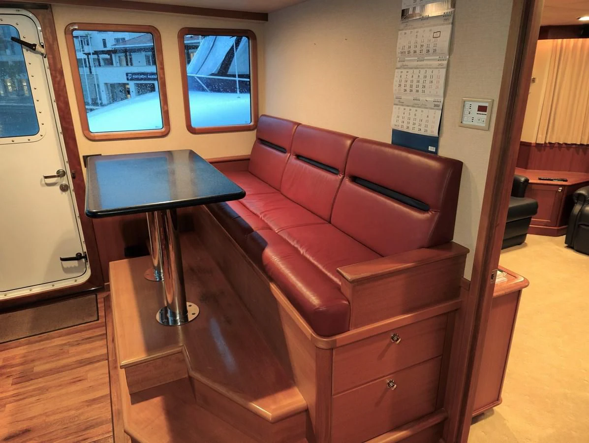 a red couch in a room aboard SPELLBOUND Yacht for Sale