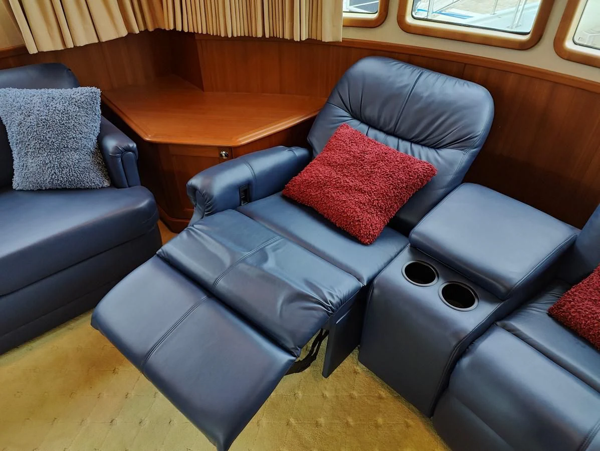 a leather couch with a red pillow aboard SPELLBOUND Yacht for Sale