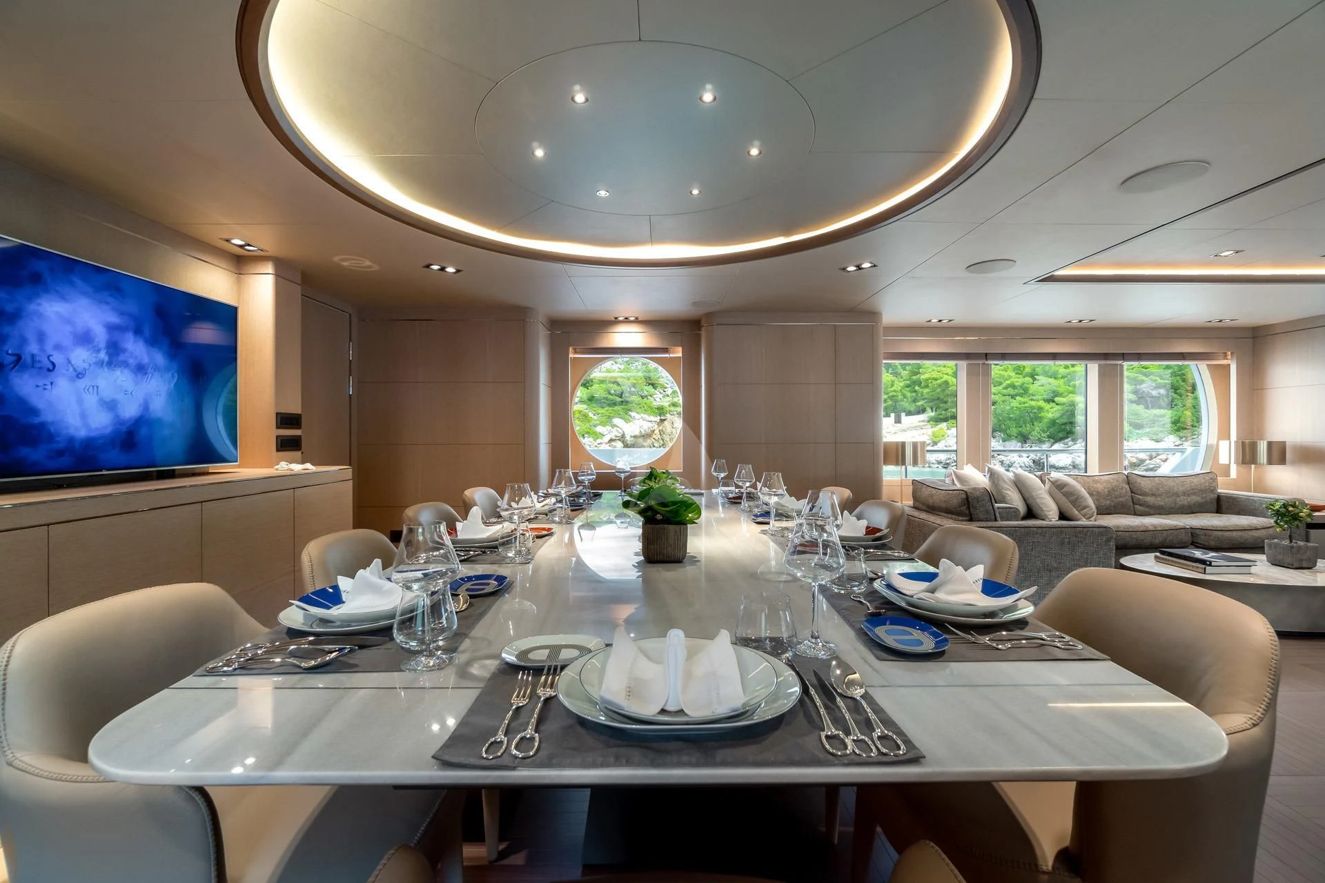a large dining room with a large screen aboard JAZ Yacht for Charter