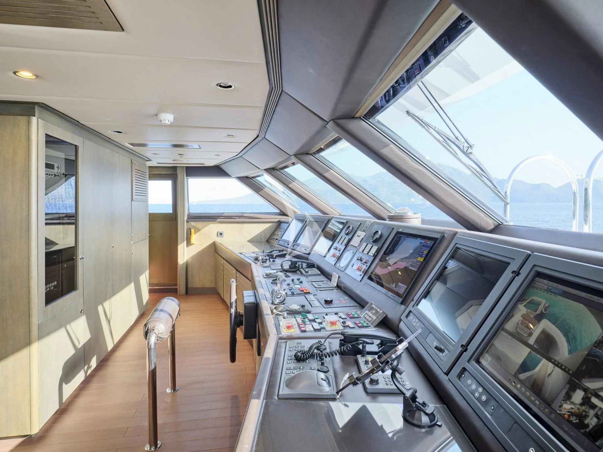 a room with a large window and a desk with computers on it aboard JAZ Yacht for Charter