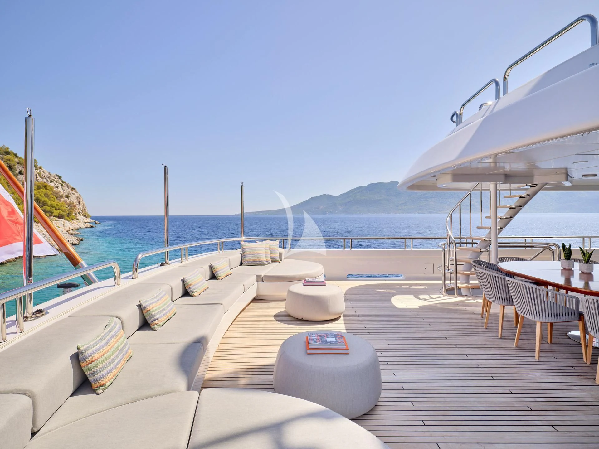 a deck with lounge chairs and a body of water in the background aboard JAZ Yacht for Charter