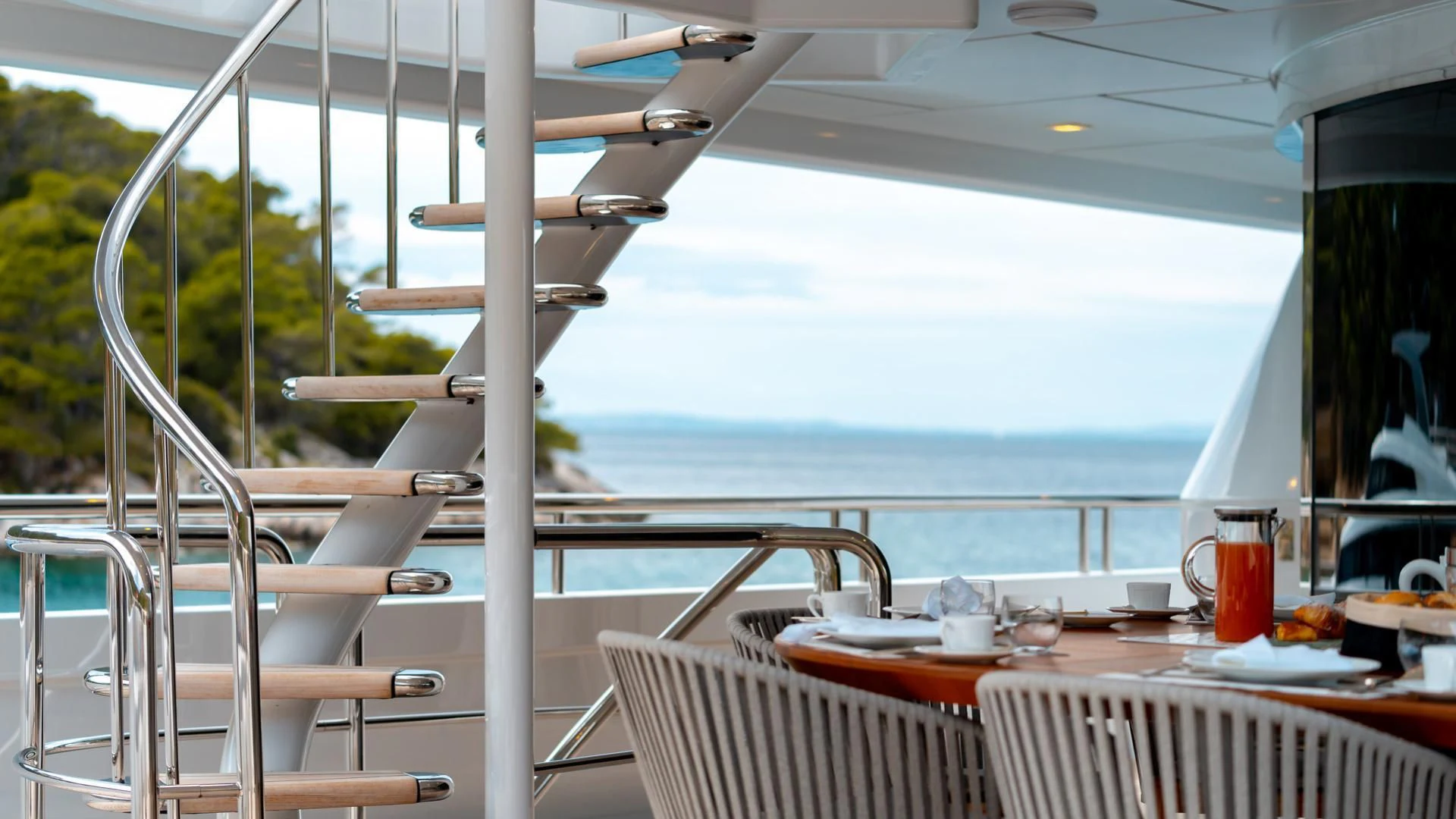 a table and chairs on a balcony aboard JAZ Yacht for Charter