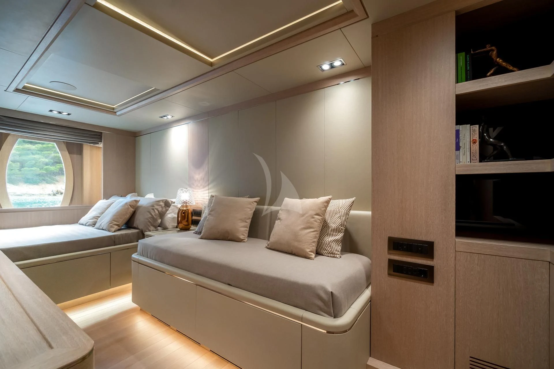 a room with a couch and a shelf with books on it aboard JAZ Yacht for Charter