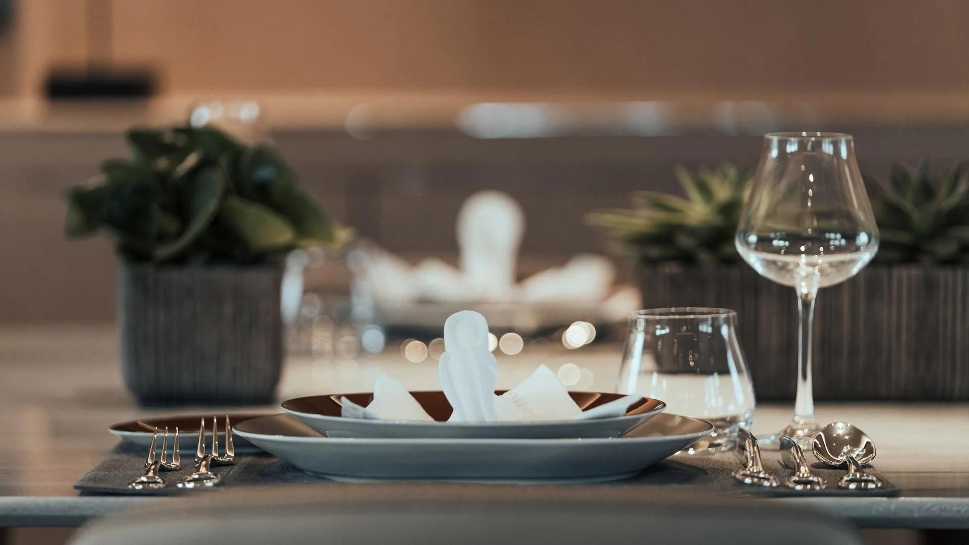 a table with a plate of food and a glass of wine aboard JAZ Yacht for Charter