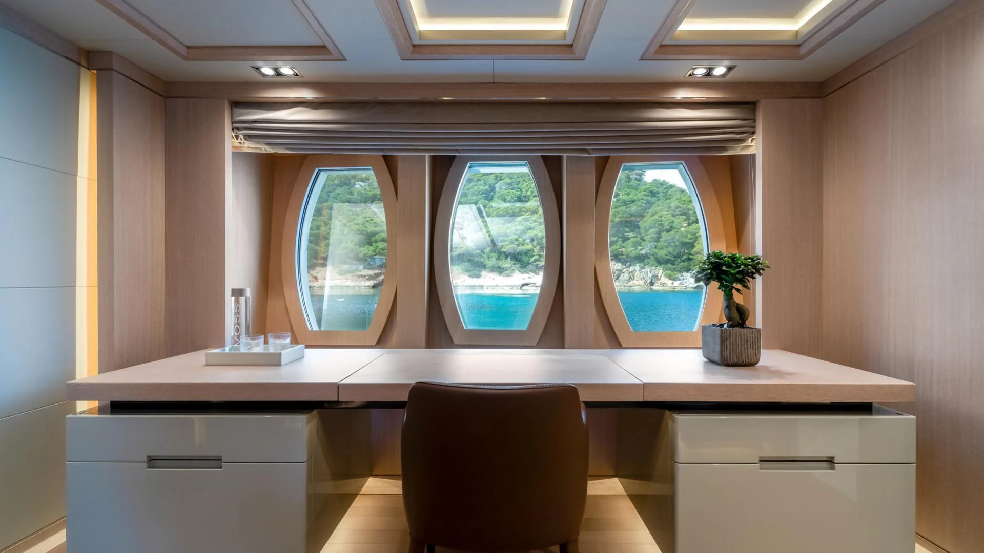 a room with a desk and a chair and a window aboard JAZ Yacht for Charter