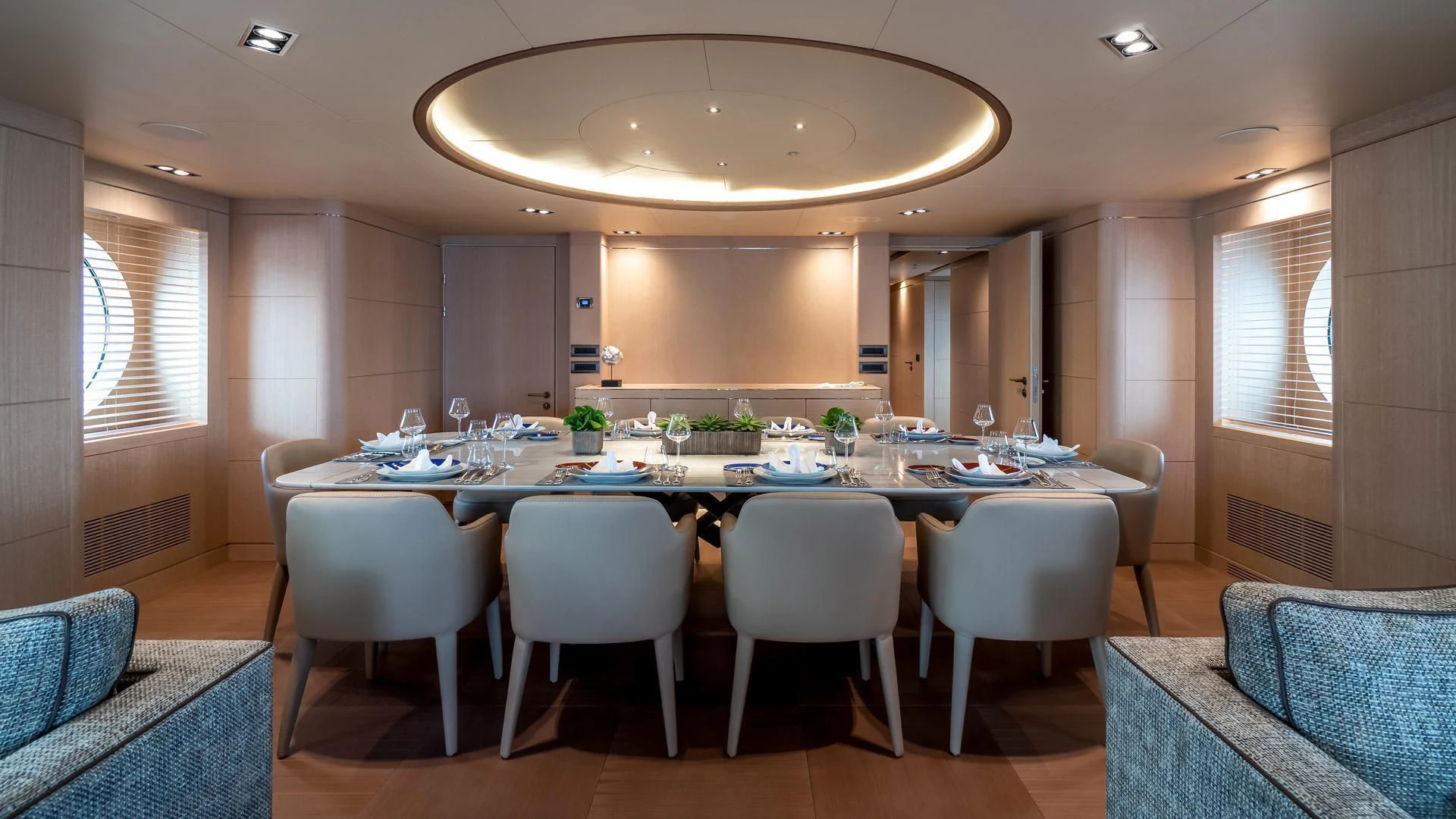 a large dining table with white chairs aboard JAZ Yacht for Charter