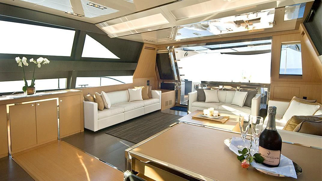 a glass bottle on a table in a room with a couch and a table aboard WHATEVER Yacht for Sale