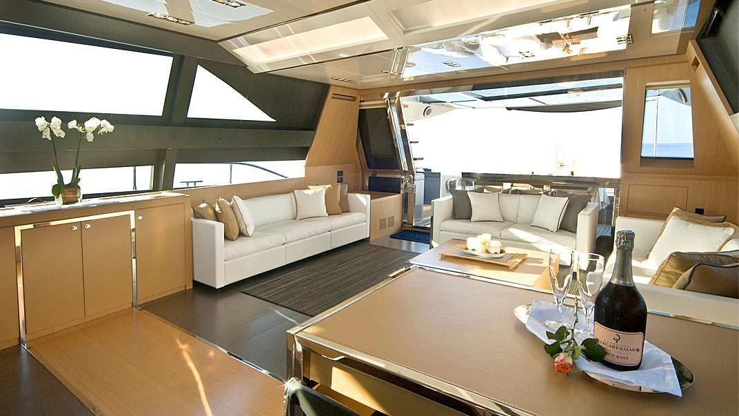 a glass bottle of wine on a table in a room with a couch and a table aboard WHATEVER Yacht for Sale