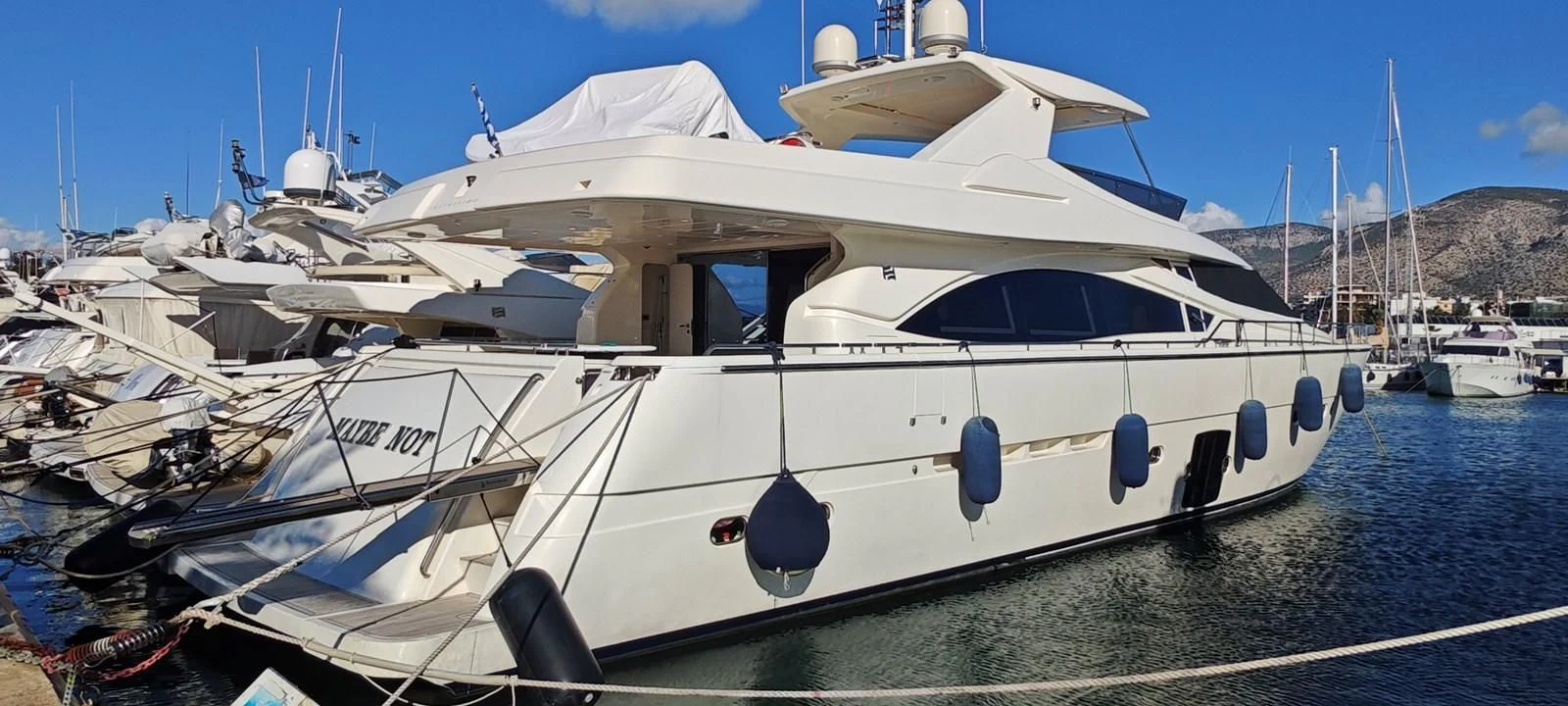 a white yacht on the water aboard MAYBE NOT Yacht for Sale