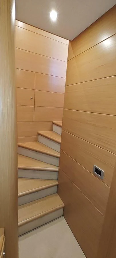 a wooden staircase with wooden drawers aboard MAYBE NOT Yacht for Sale