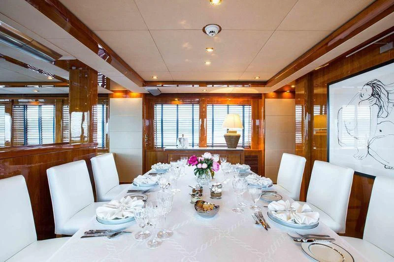 a large white table with plates and chairs aboard FRIVOLOUS Yacht for Sale