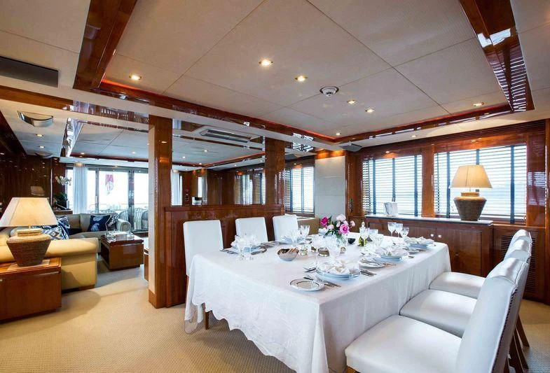 a large room with a table and chairs aboard FRIVOLOUS Yacht for Sale