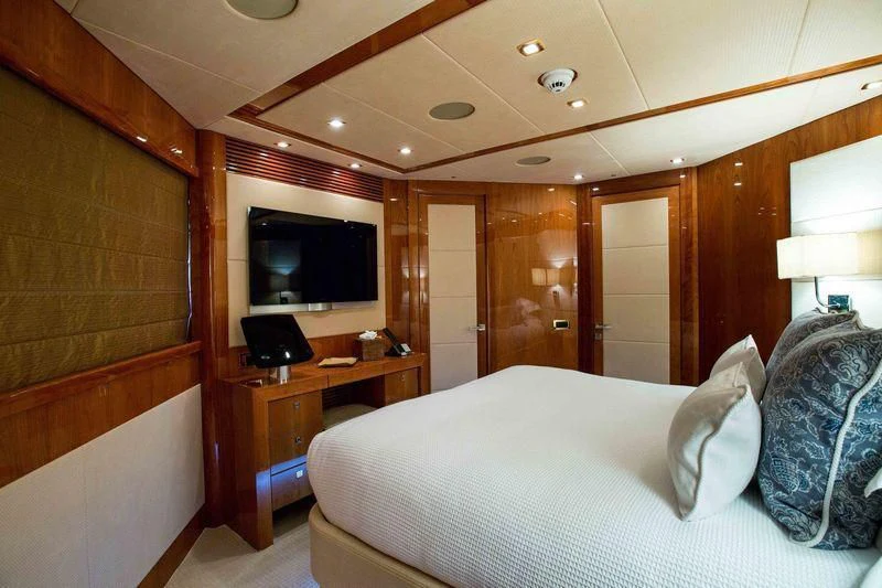a bedroom with a bed and a television aboard FRIVOLOUS Yacht for Sale