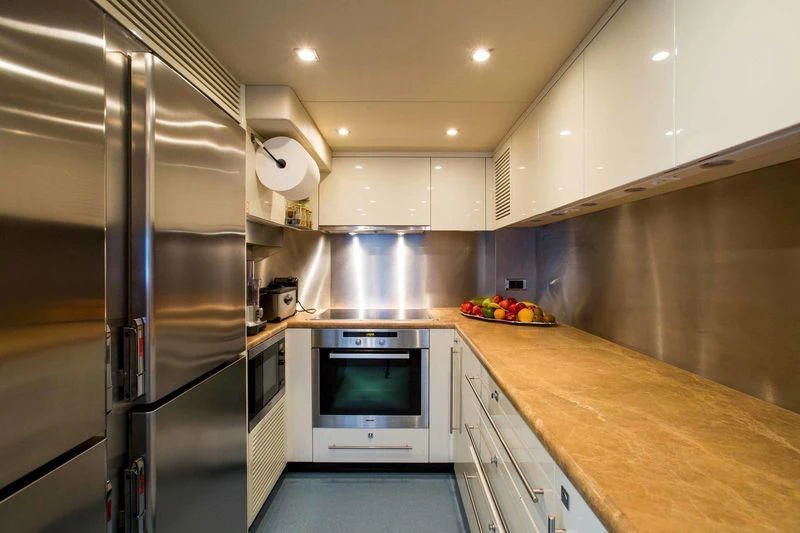 a kitchen with stainless steel appliances aboard FRIVOLOUS Yacht for Sale