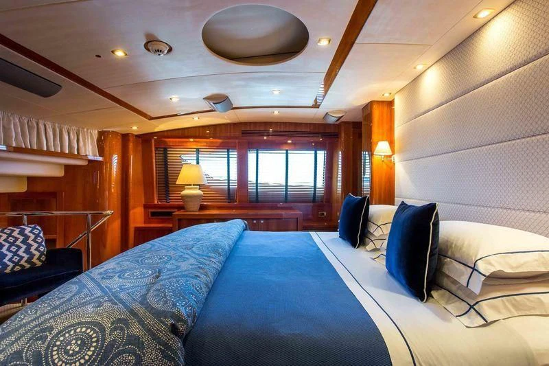 a room with a bed and a table aboard FRIVOLOUS Yacht for Sale