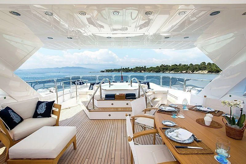 a room with a table chairs and a large body of water aboard FRIVOLOUS Yacht for Sale