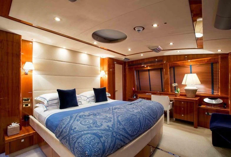 a bedroom with a bed and a desk aboard FRIVOLOUS Yacht for Sale