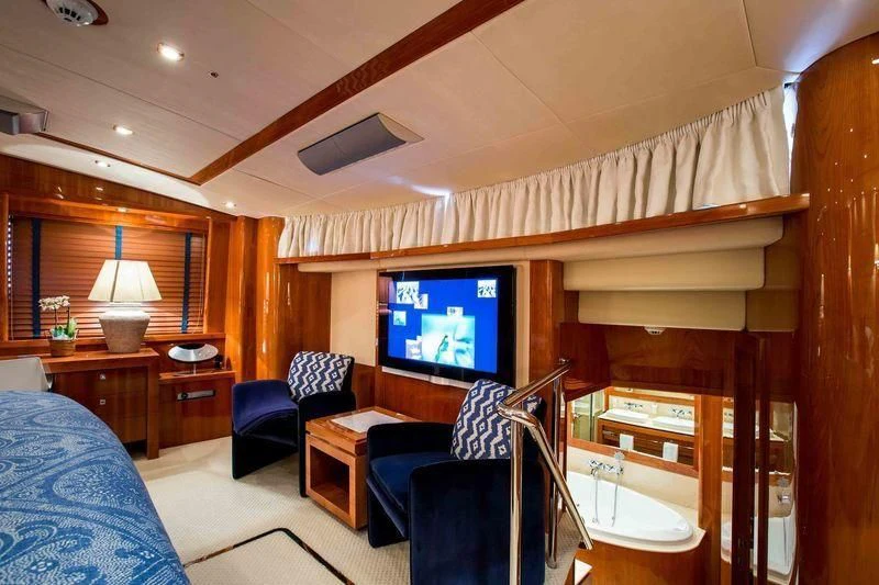 a living room with a tv and furniture aboard FRIVOLOUS Yacht for Sale