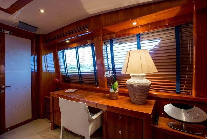 a room with a table and a lamp aboard FRIVOLOUS Yacht for Sale