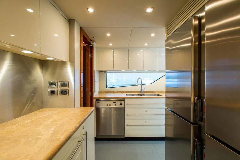 a kitchen with a stainless steel refrigerator aboard FRIVOLOUS Yacht for Sale