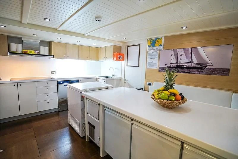 a kitchen with a bowl of fruit on the island aboard TUYIKA S Yacht for Sale