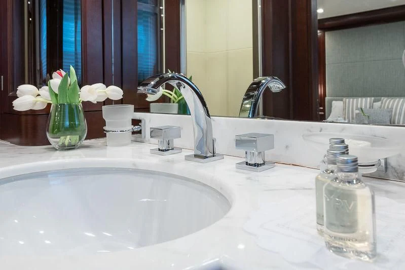 a bathroom sink with a vase of flowers on it aboard ELENA NUEVE Yacht for Charter