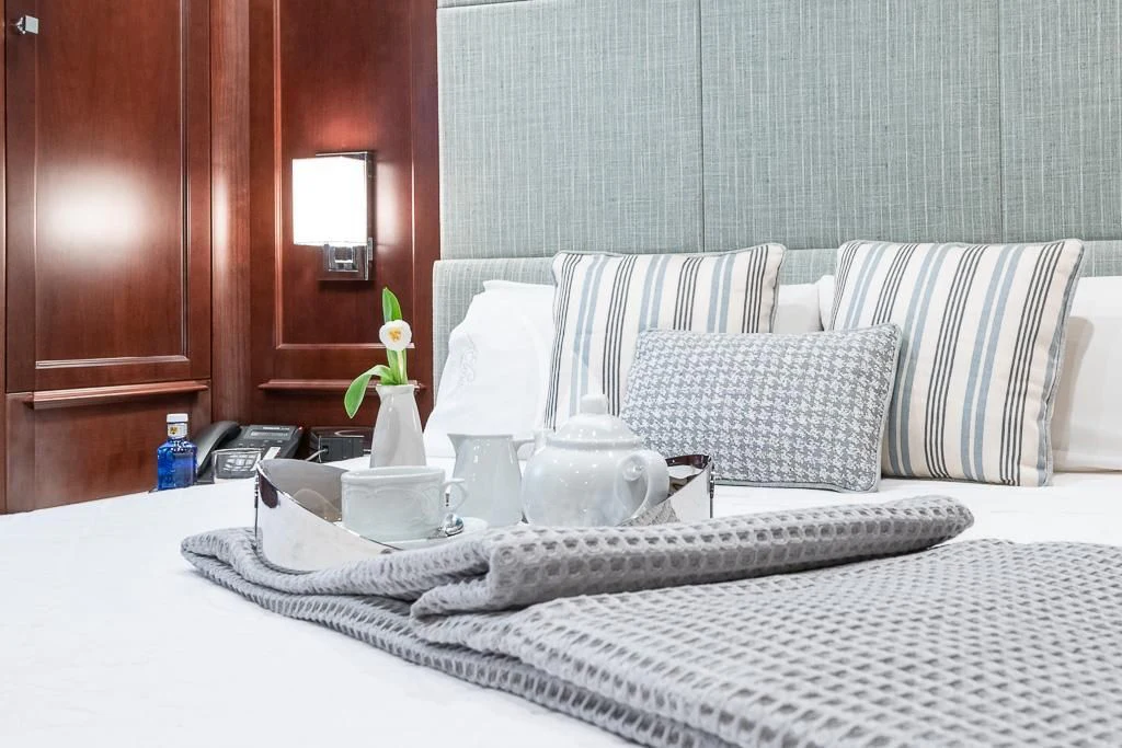 a bed with pillows and a vase aboard ELENA NUEVE Yacht for Charter