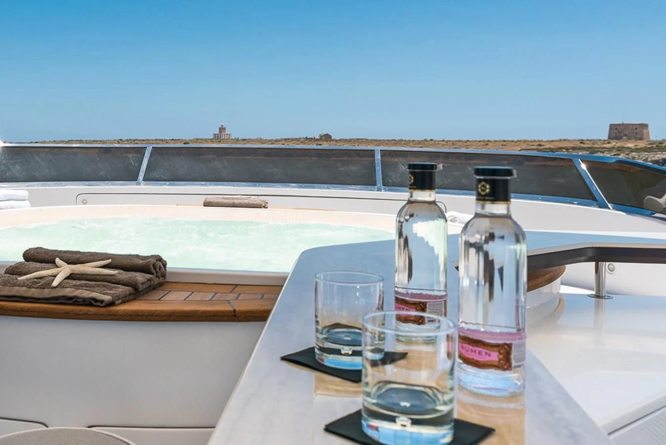 a bottle and a glass of water on a boat aboard ELENA NUEVE Yacht for Charter