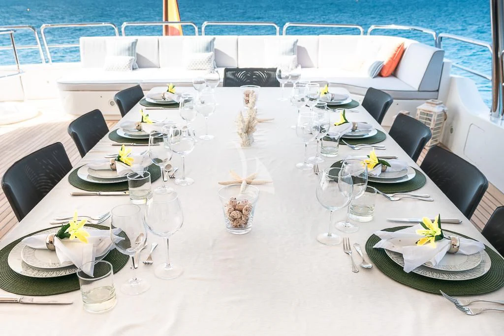 a table set for a dinner party aboard ELENA NUEVE Yacht for Charter