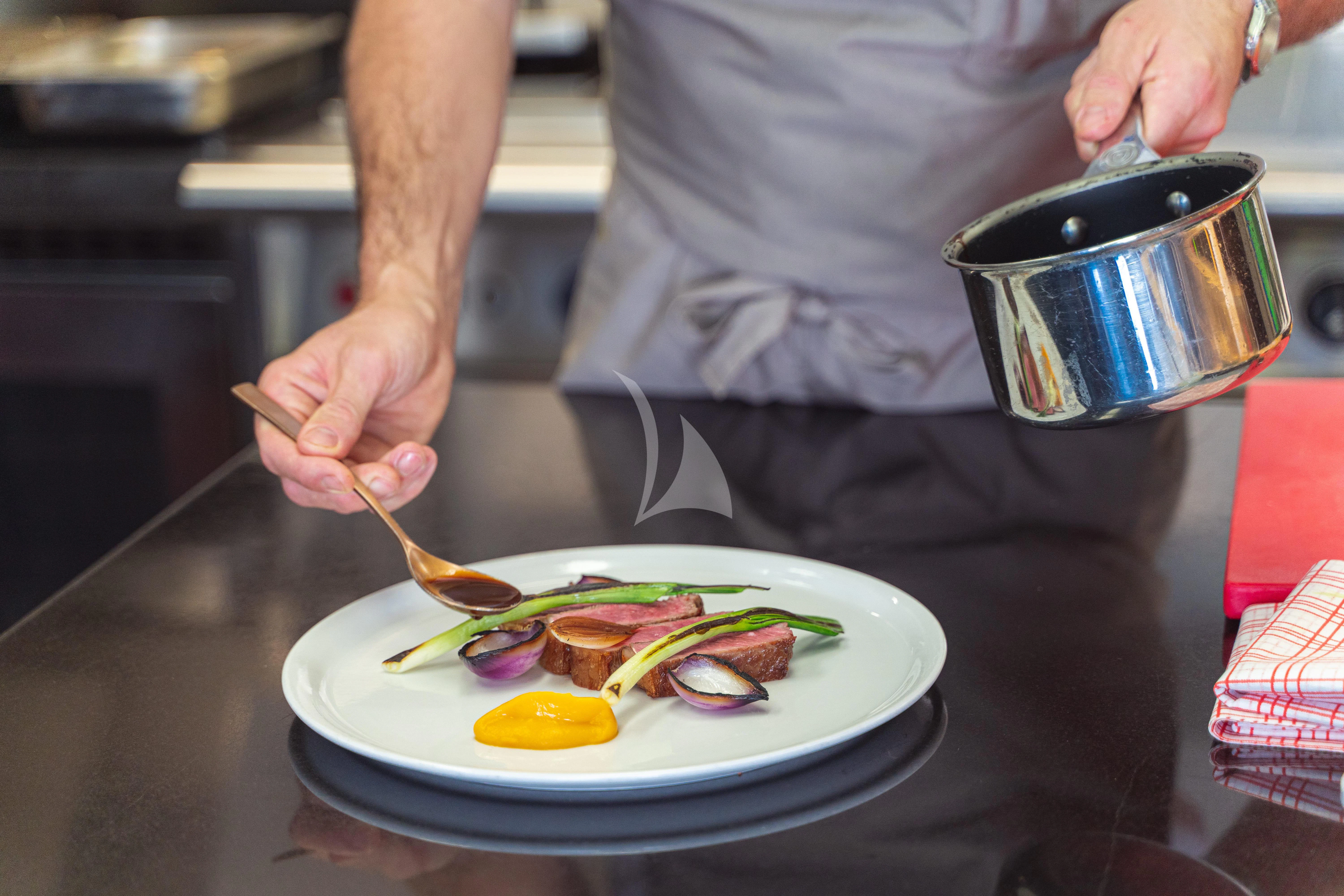 a person cooking food aboard TRIDENT Yacht for Charter