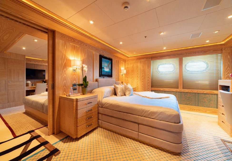 a bedroom with a bed and a window aboard TRIDENT Yacht for Charter