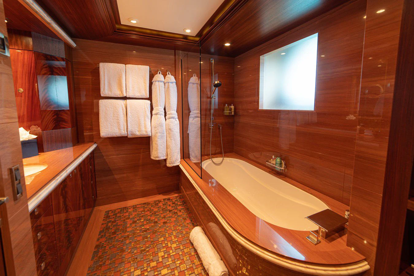 a bathroom with a tub sink and a mirror aboard TRIDENT Yacht for Charter