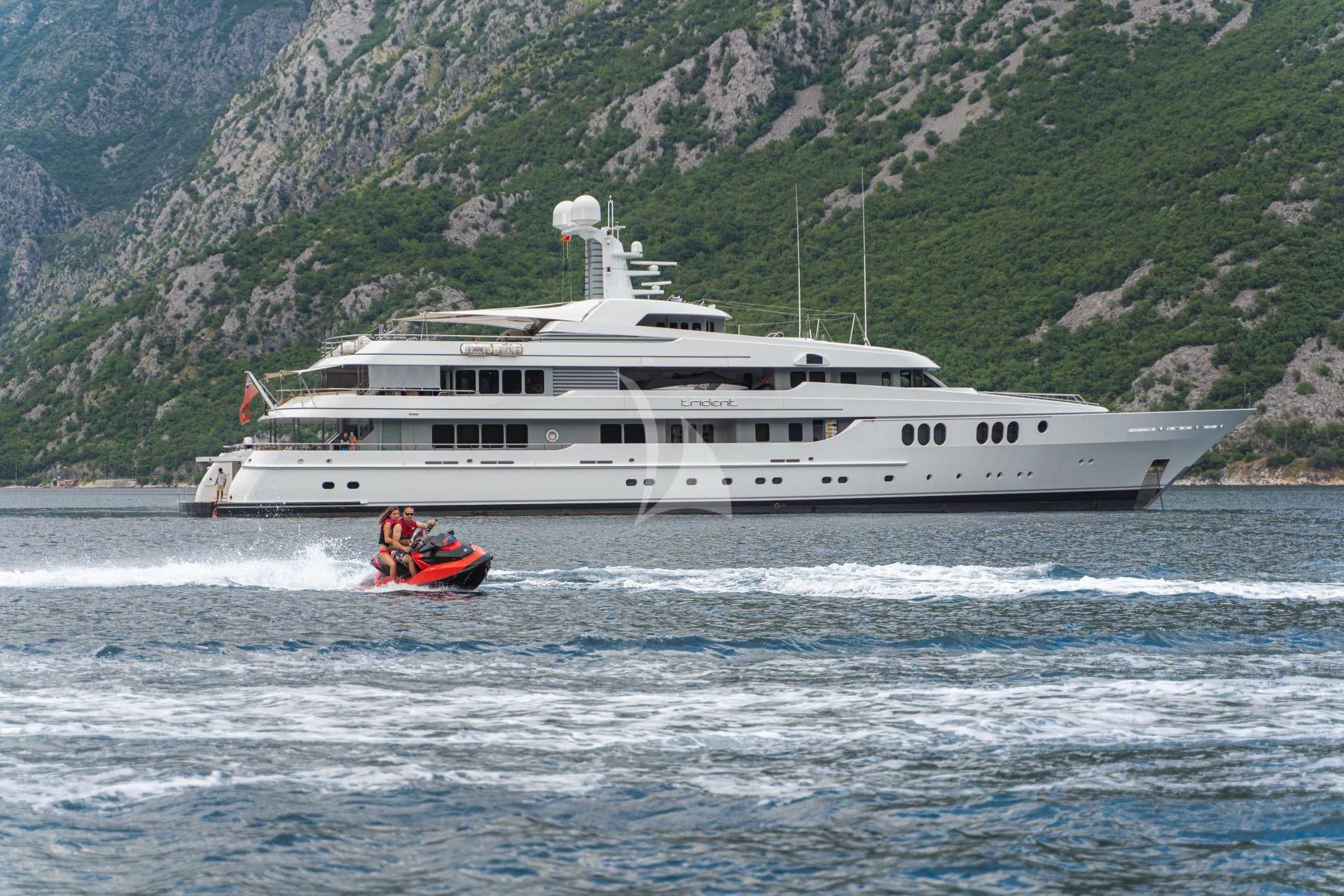 a boat in the water with a boat in the background aboard TRIDENT Yacht for Charter