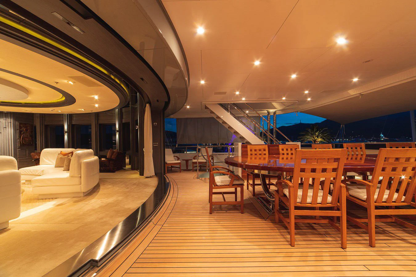 a room with a wood floor and a wood table with chairs and a large window with a view aboard TRIDENT Yacht for Charter