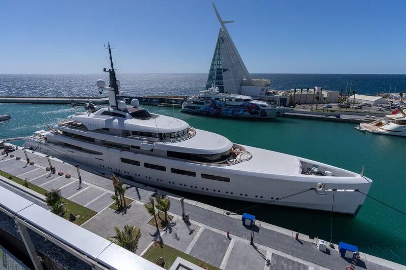 a large white ship docked at a port aboard VAVA II Yacht for Sale