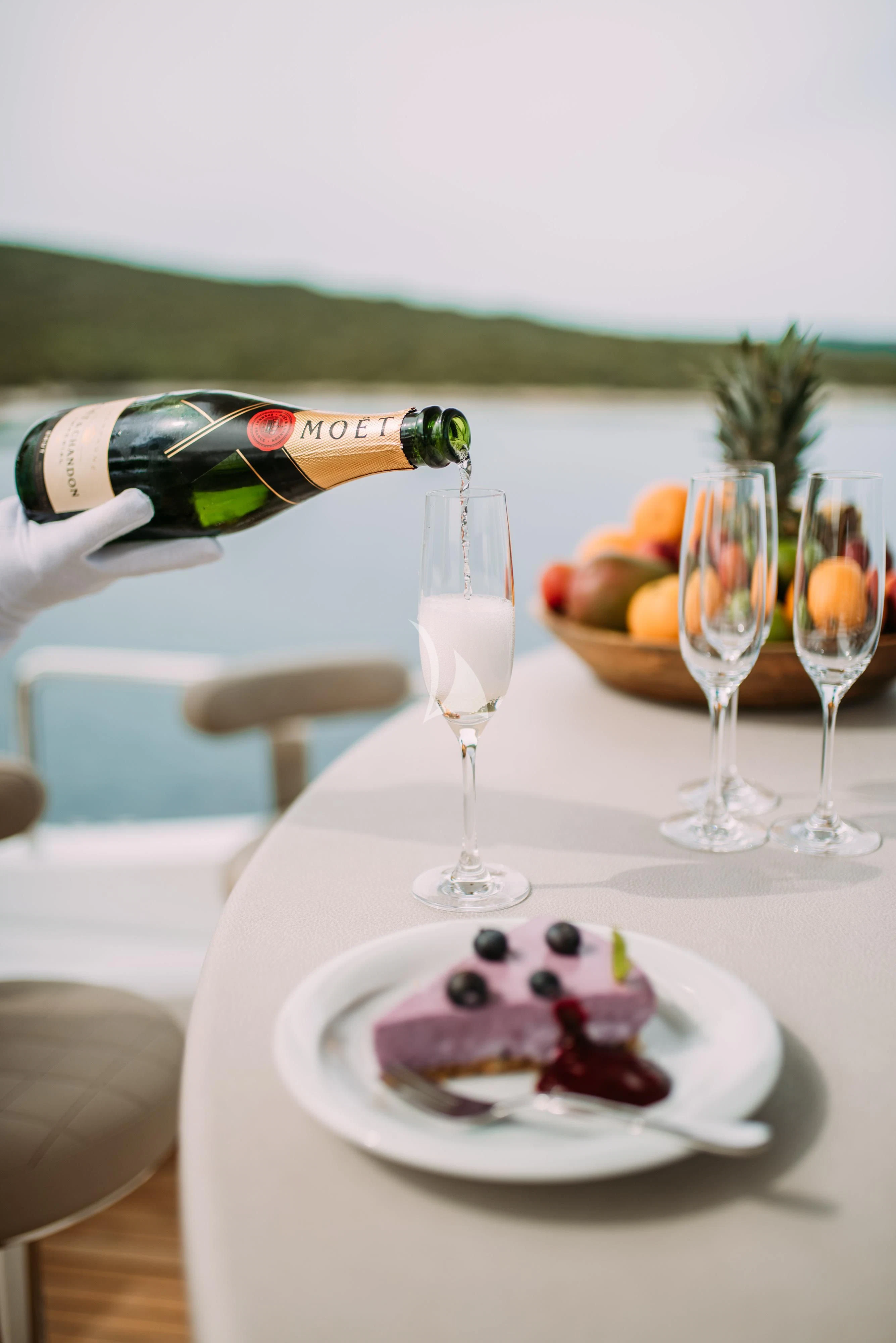 a bottle of wine and a plate of dessert on a table aboard ARTEMY Yacht for Sale