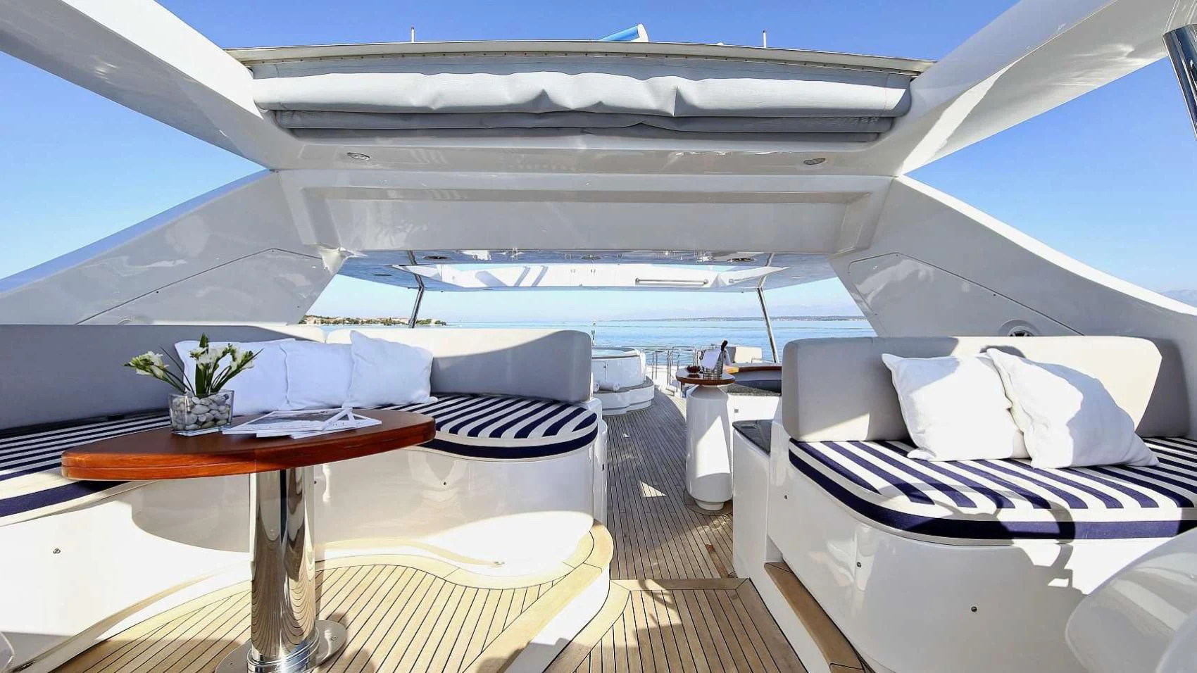 a room with a large bed and a table with chairs aboard ARTEMY Yacht for Sale