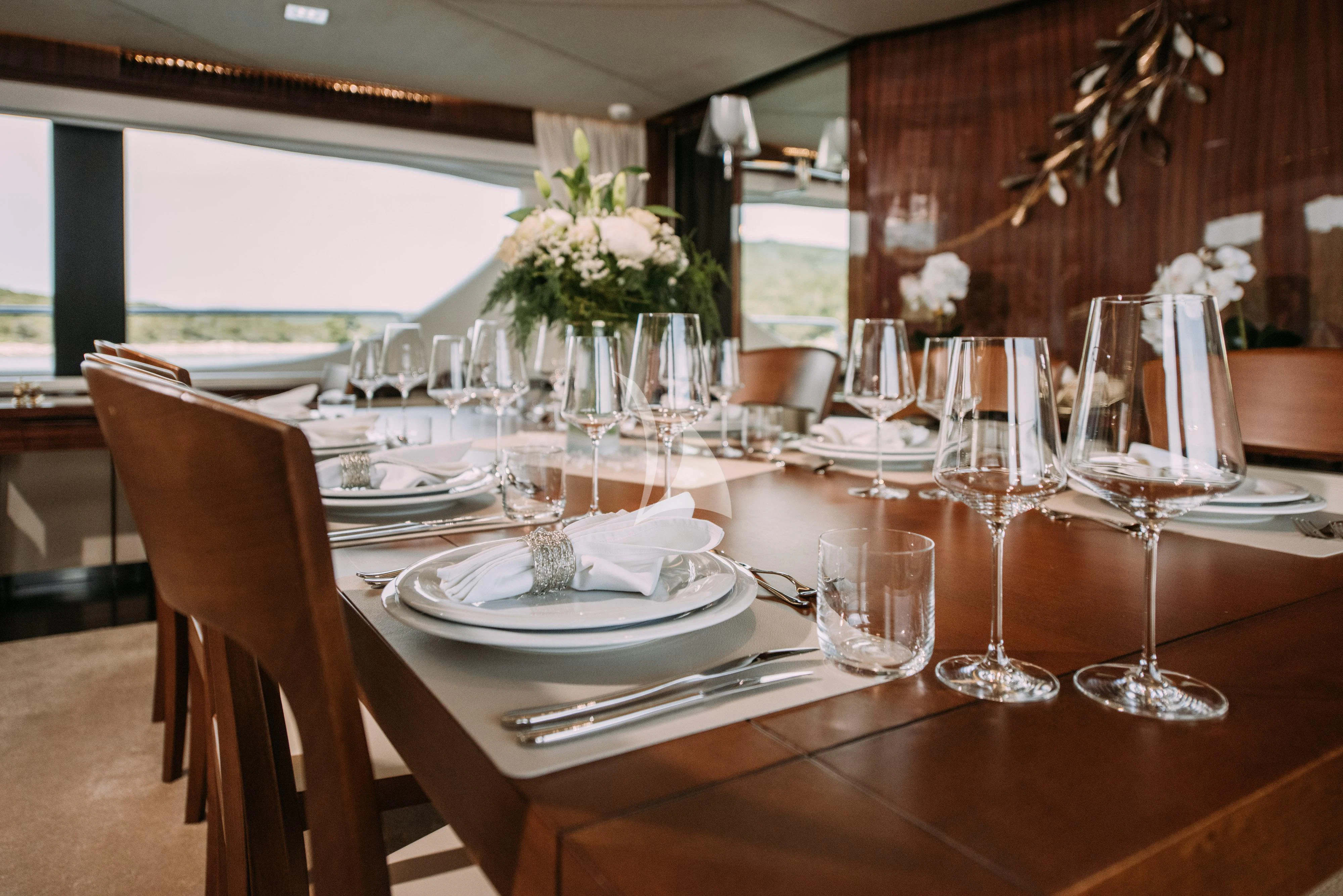 a table with wine glasses and flowers aboard ARTEMY Yacht for Sale