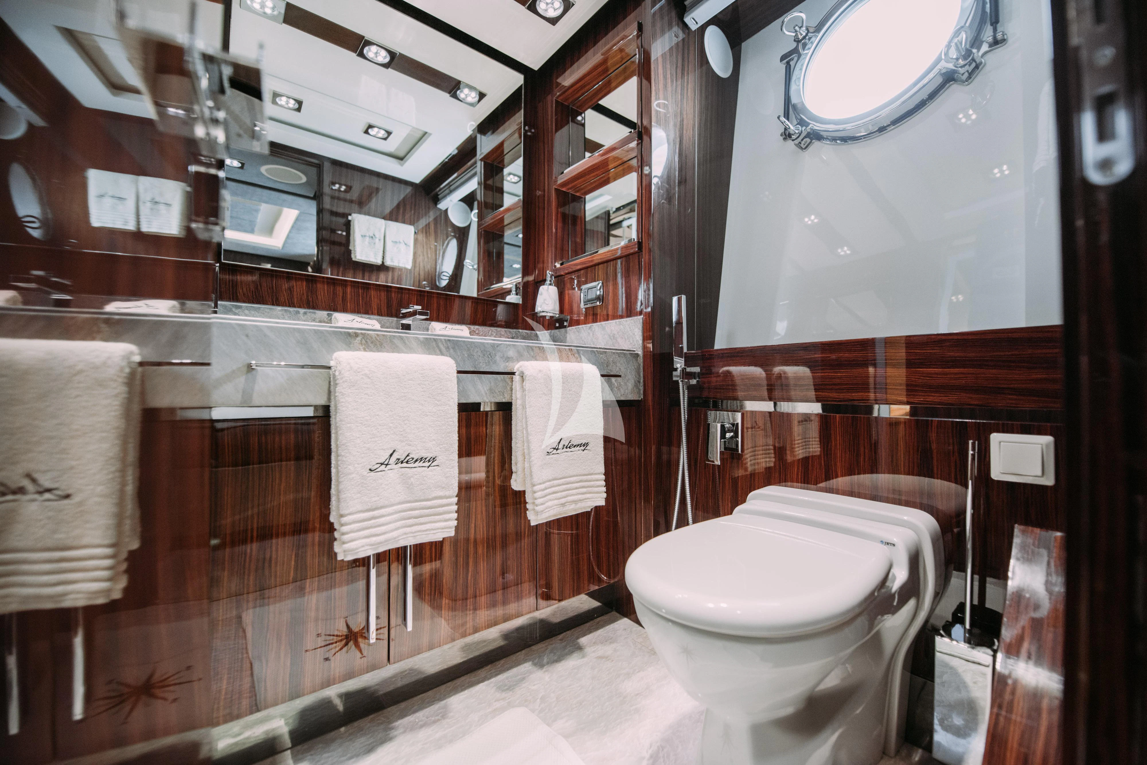 a bathroom with a toilet and a mirror aboard ARTEMY Yacht for Sale