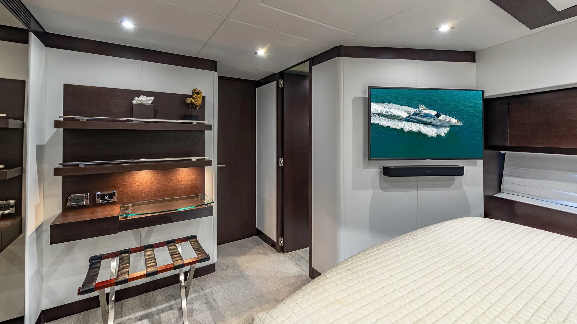a room with a bed and a television aboard M Yacht for Charter