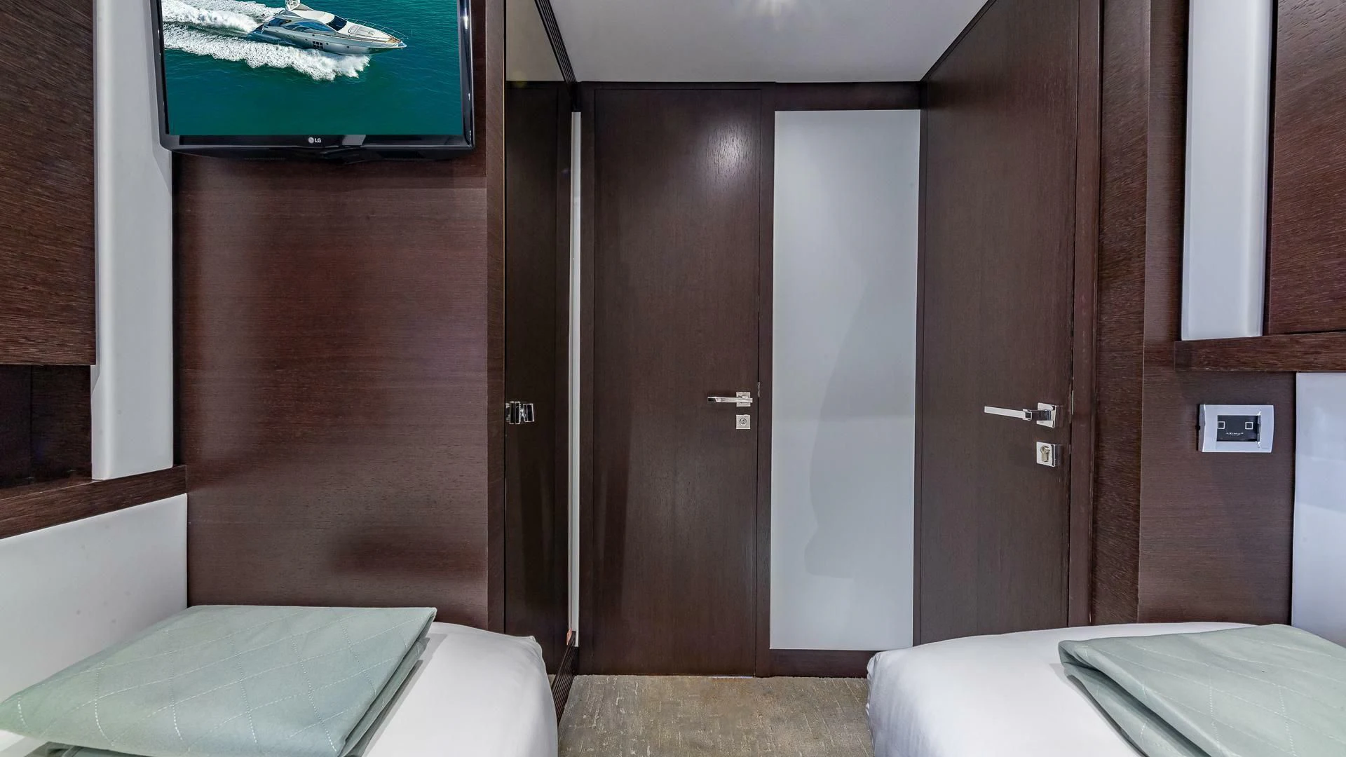 a room with a bed and a television on the wall aboard M Yacht for Charter