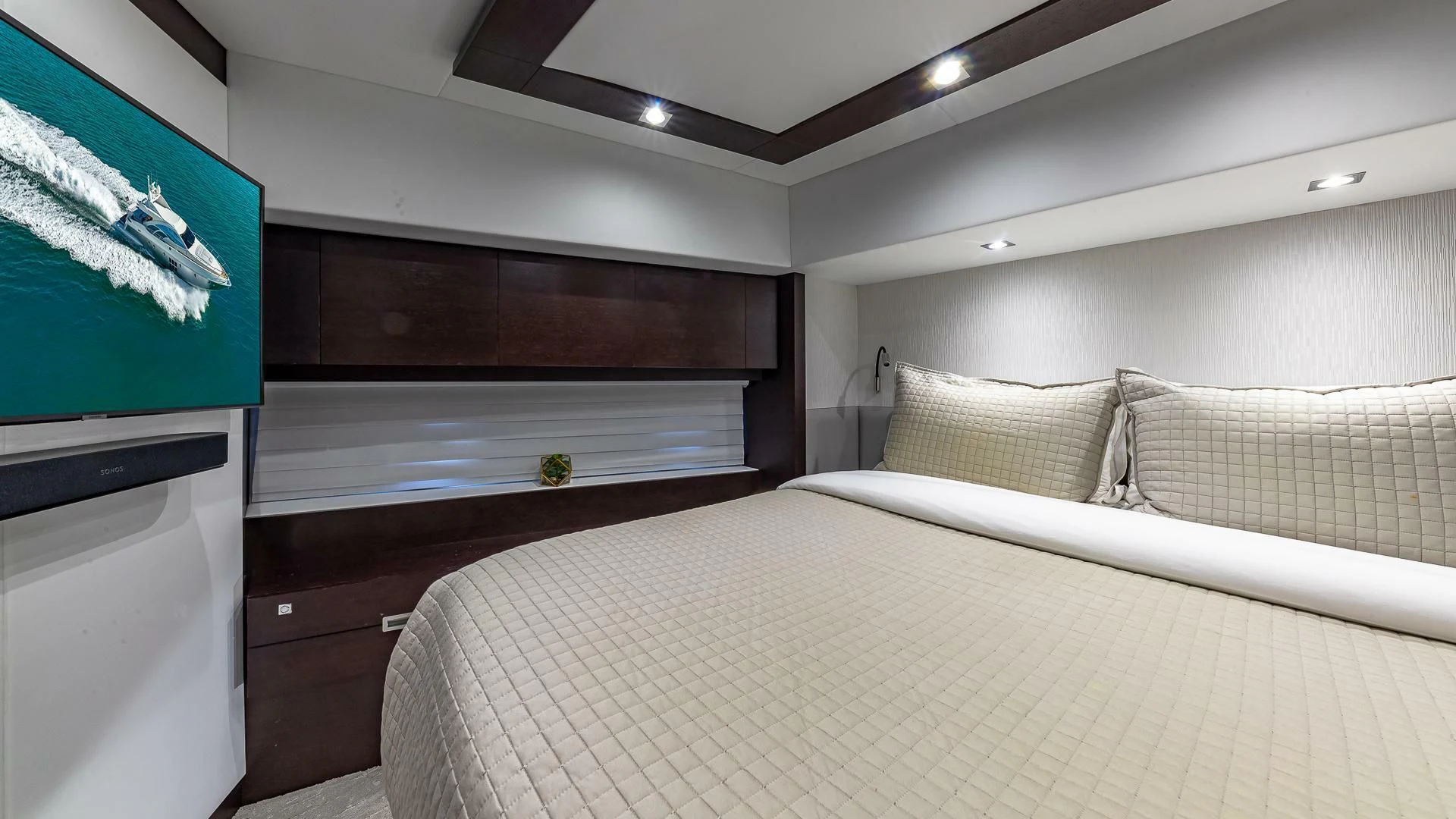 a room with a bed and a television aboard M Yacht for Charter