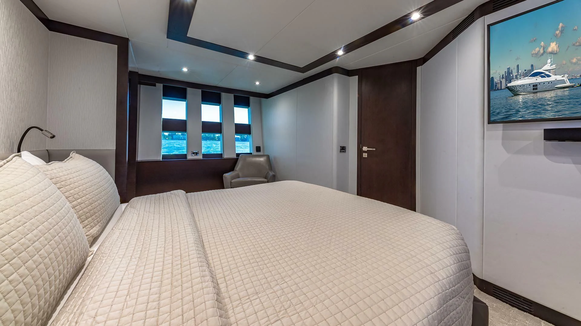 a bed with a television on the wall aboard M Yacht for Charter