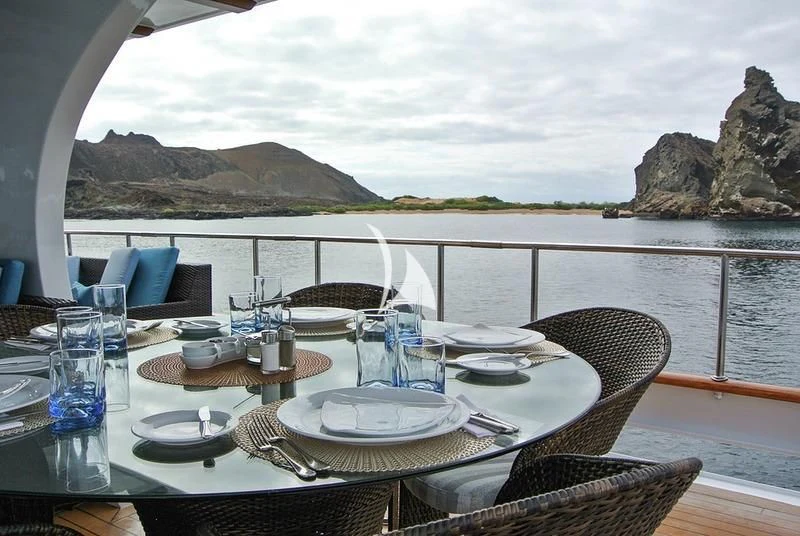 a table set for a dinner on the beach aboard GALAPAGOS EXPLORER Yacht for Sale