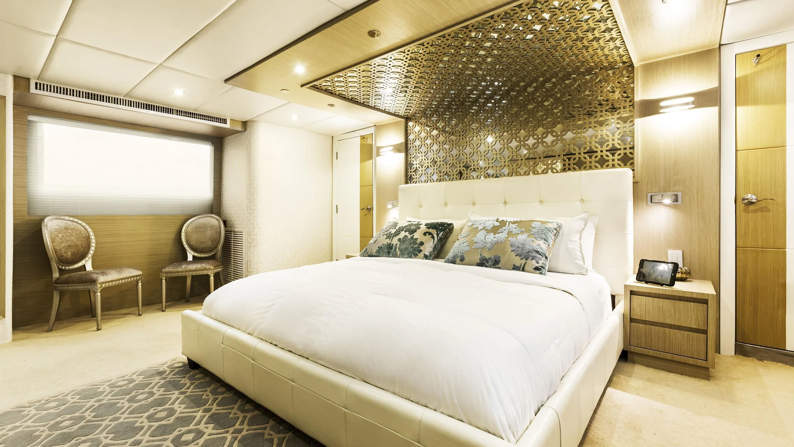 a large bedroom with a bed and chairs aboard GALAPAGOS EXPLORER Yacht for Sale