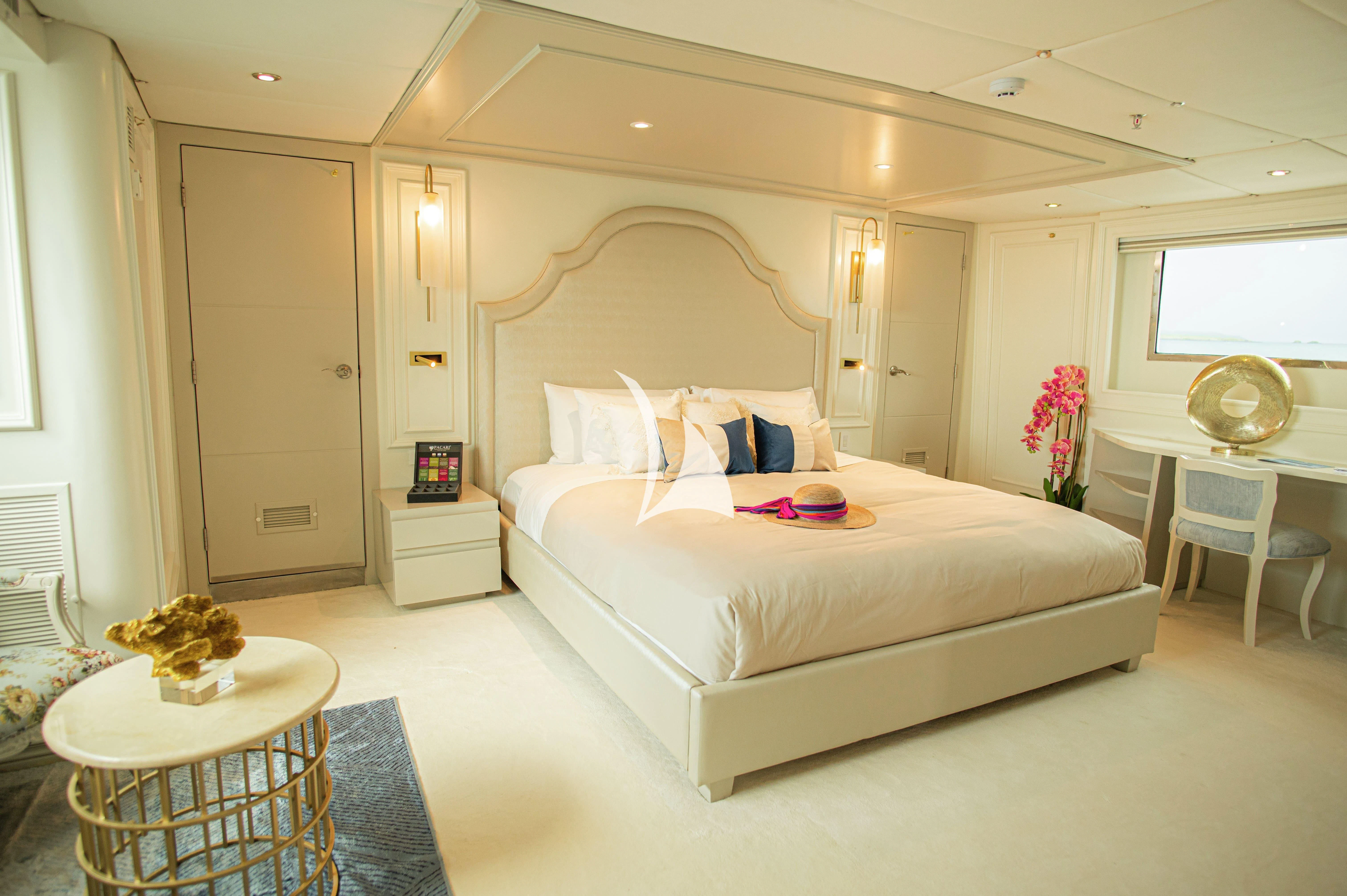 a bedroom with a bed and a table aboard GALAPAGOS EXPLORER Yacht for Sale