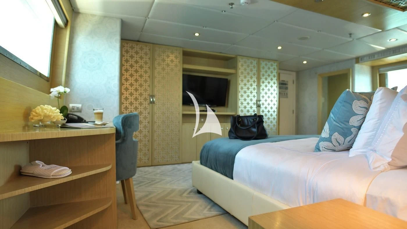 a room with a bed and a desk aboard GALAPAGOS EXPLORER Yacht for Sale